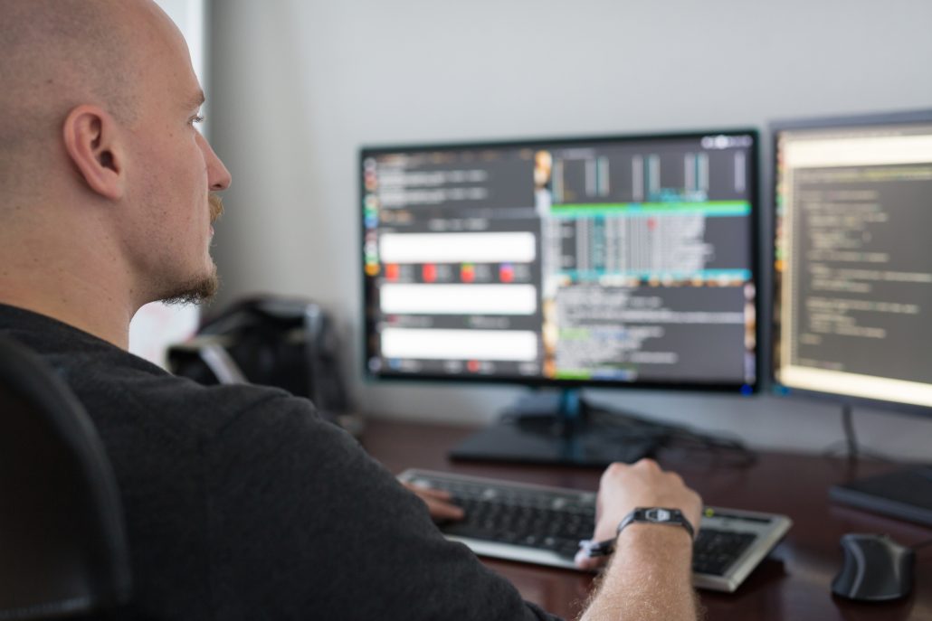 Kille som sitter och programmerar framför en dator