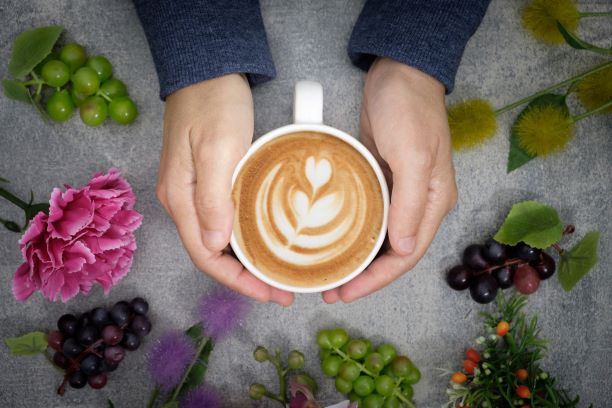 Två händer som håller runt en kaffekopp.