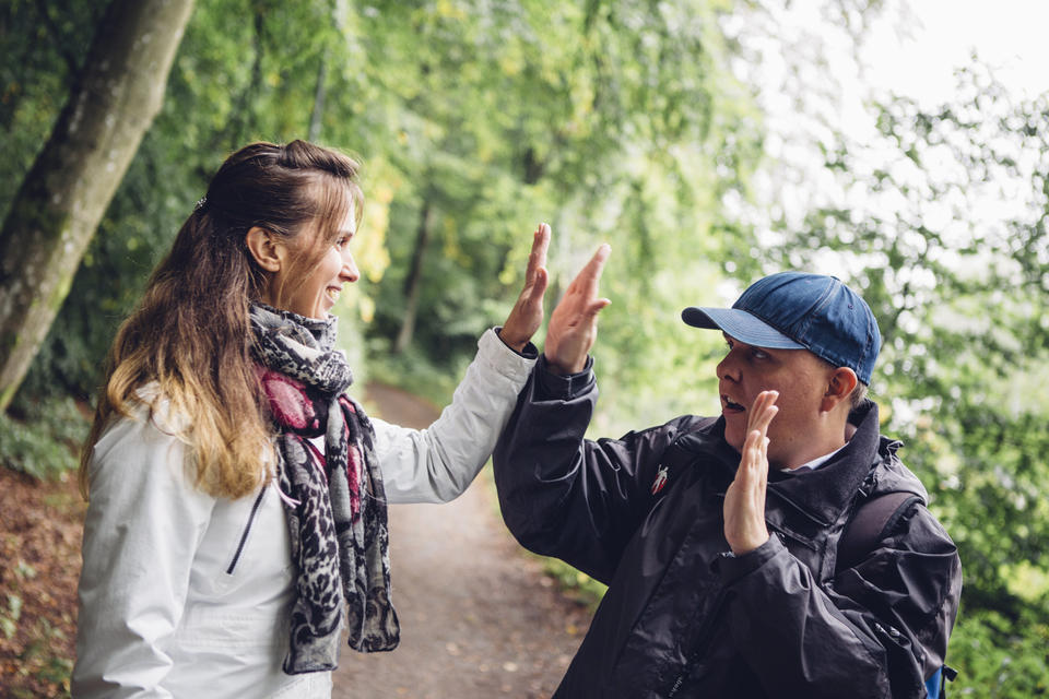 Personlig assistent gör highfive med sin brukare