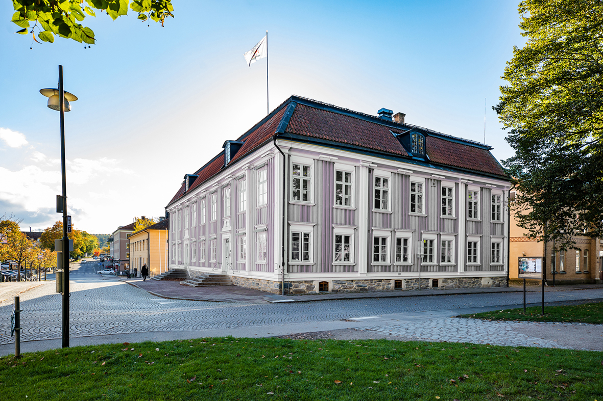 Bild på Alingsås rådhus med lila-grå fasad. 