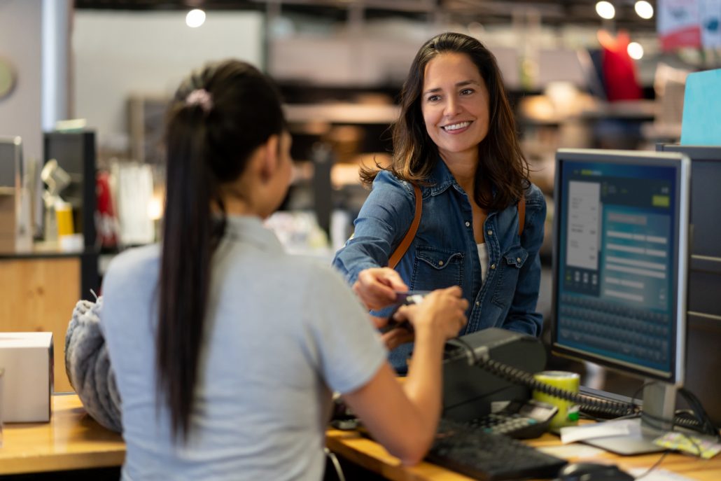 Tjej som betalar med kort i en butik