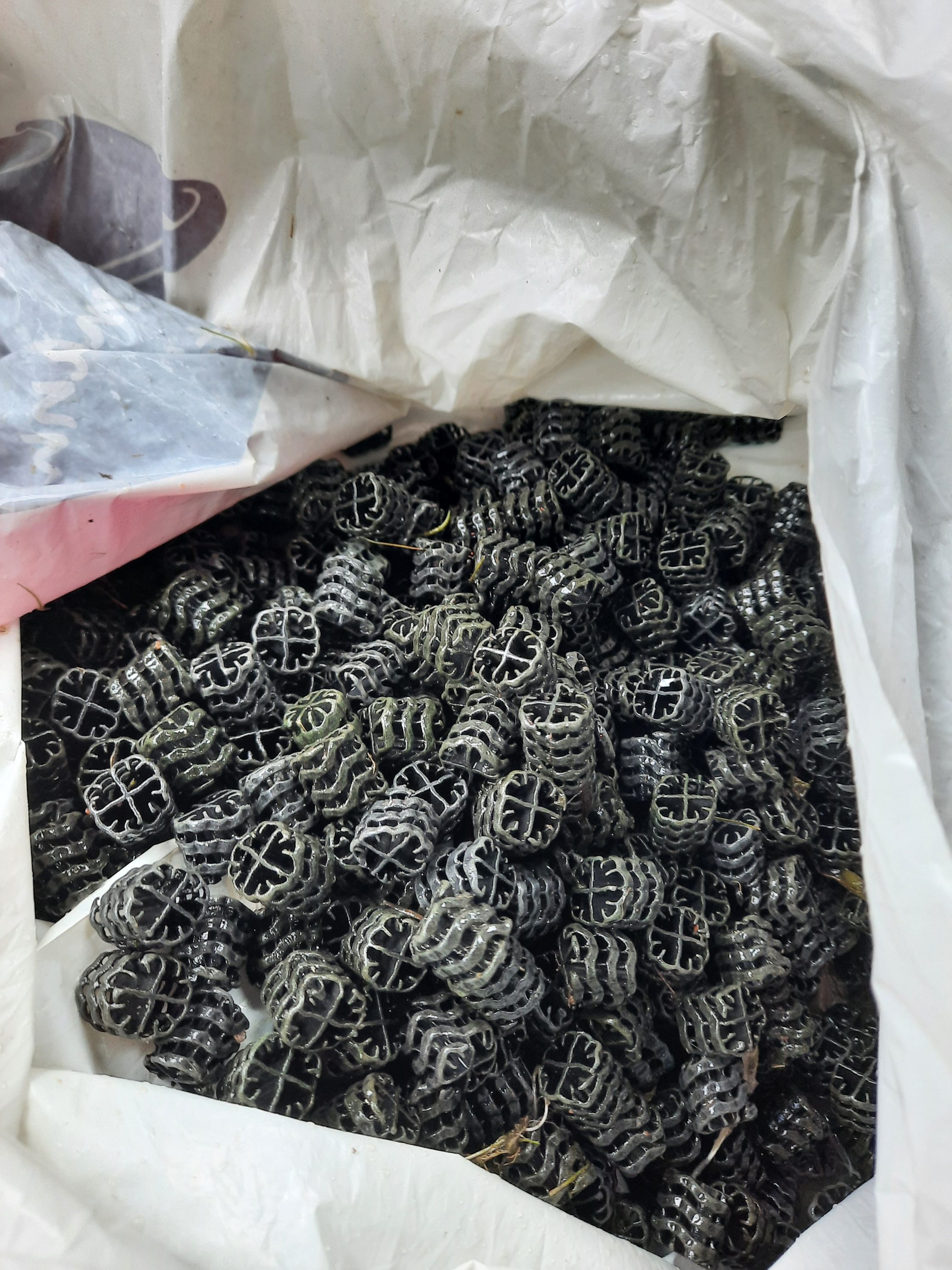 Påse full med filterbollar av svart plast