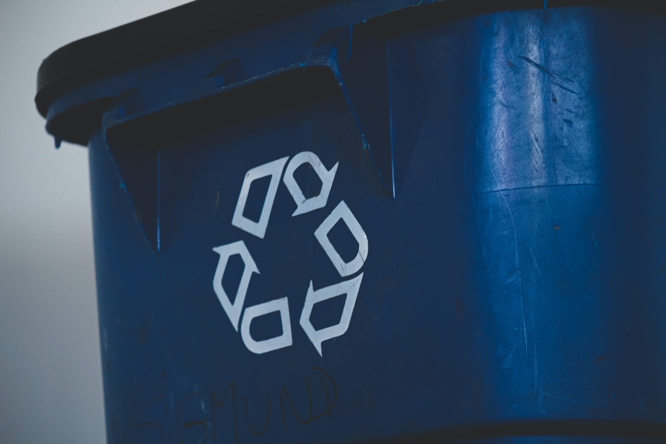 Sopkärl med symbol för återvinning på.