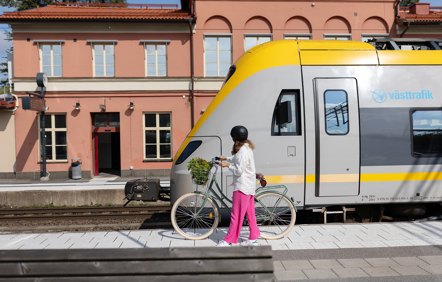 En cyklist intill ett tåg på Alingsås station.